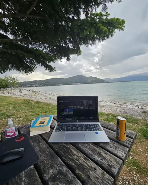 Laptop on a picnic table by a lake